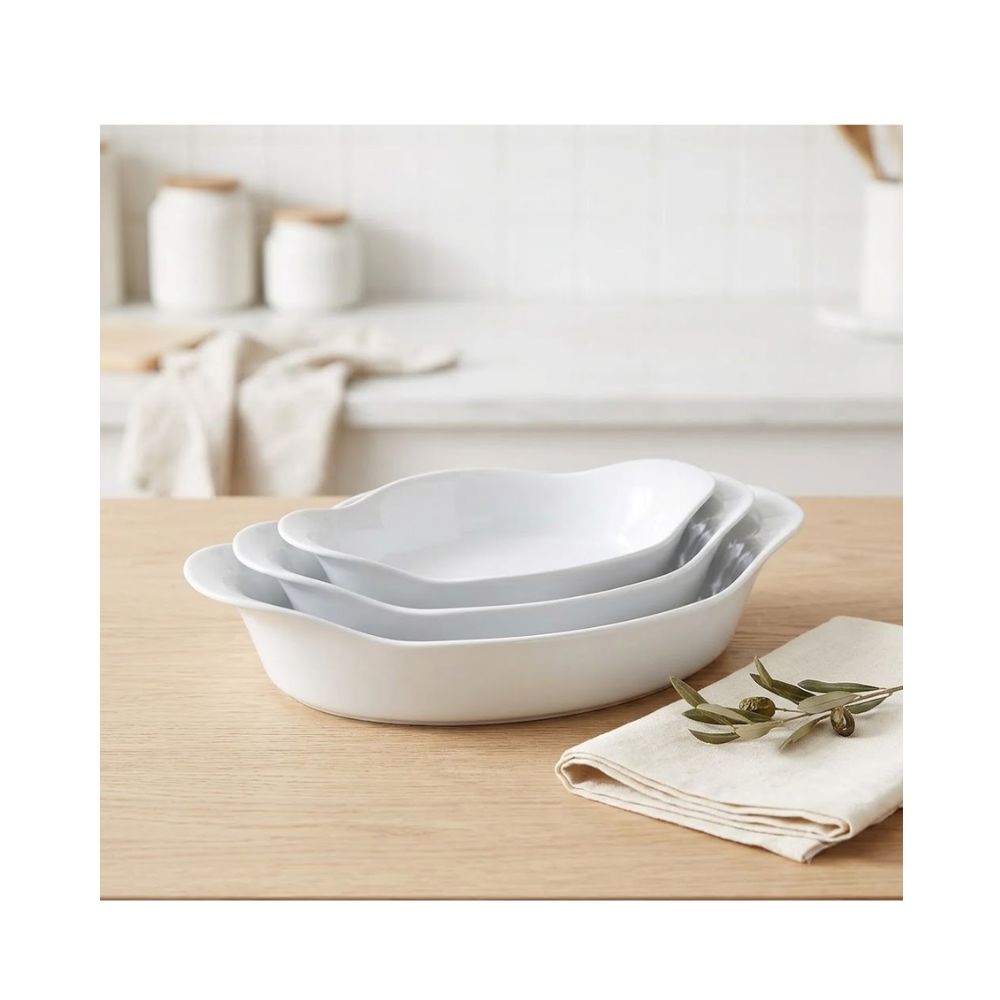 Conjunto com três assadeiras ovais de vidro opaline branco da marca Marinex, apresentadas em tamanhos diferentes (pequena, média e grande) e empilhadas.